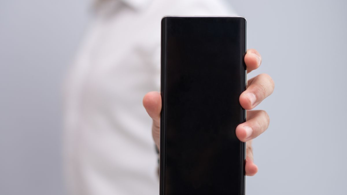 Male hand holding modern Android smartphone inspecting mobile gallery storage